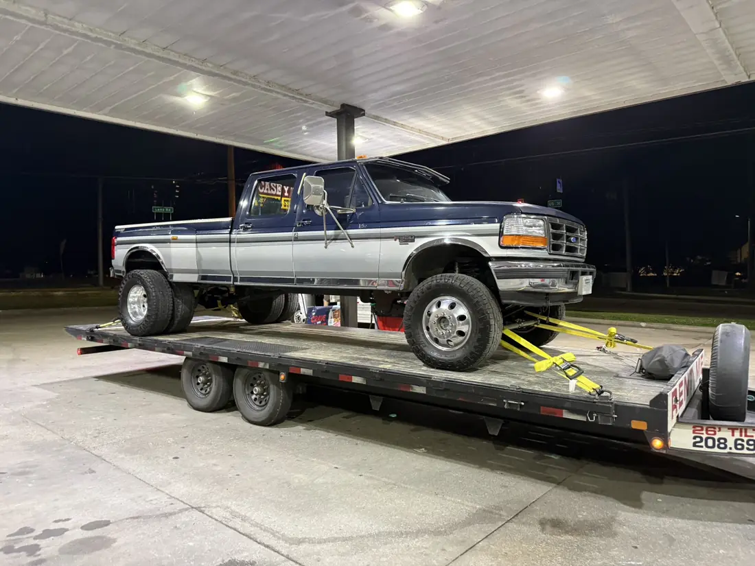 Lifted pickup truck secured on the matching 26-foot Rayzart tilt-deck trailer
